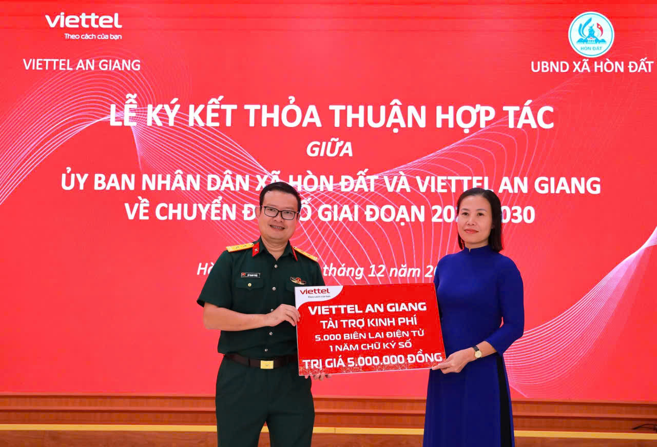 Ảnh 2: Đồng chí Trung tá Đỗ Thanh Tuấn – Phó Bí thư Đảng ủy, Giám đốc Viettel An Giang trao tặng bản tượng trưng hỗ trợ kinh phí 5000 biên lai điện tử, một năm chữ ký số cho lãnh đạo xã Hòn Đất.